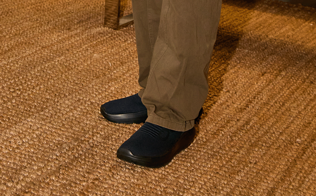Men's OOmy Zen - Black close up of shoe on model standing on rug | lifestyle