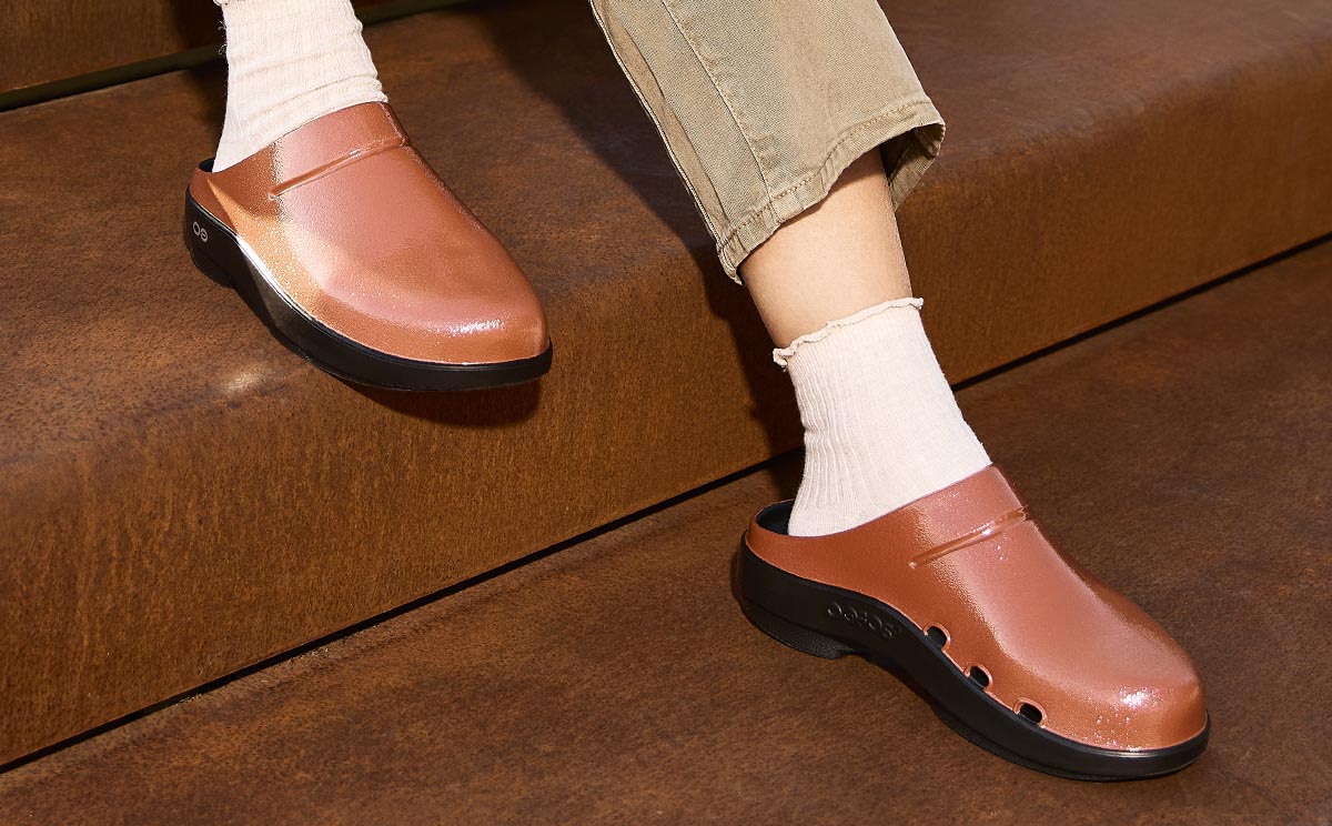 model sitting on steps wearing copper clog
