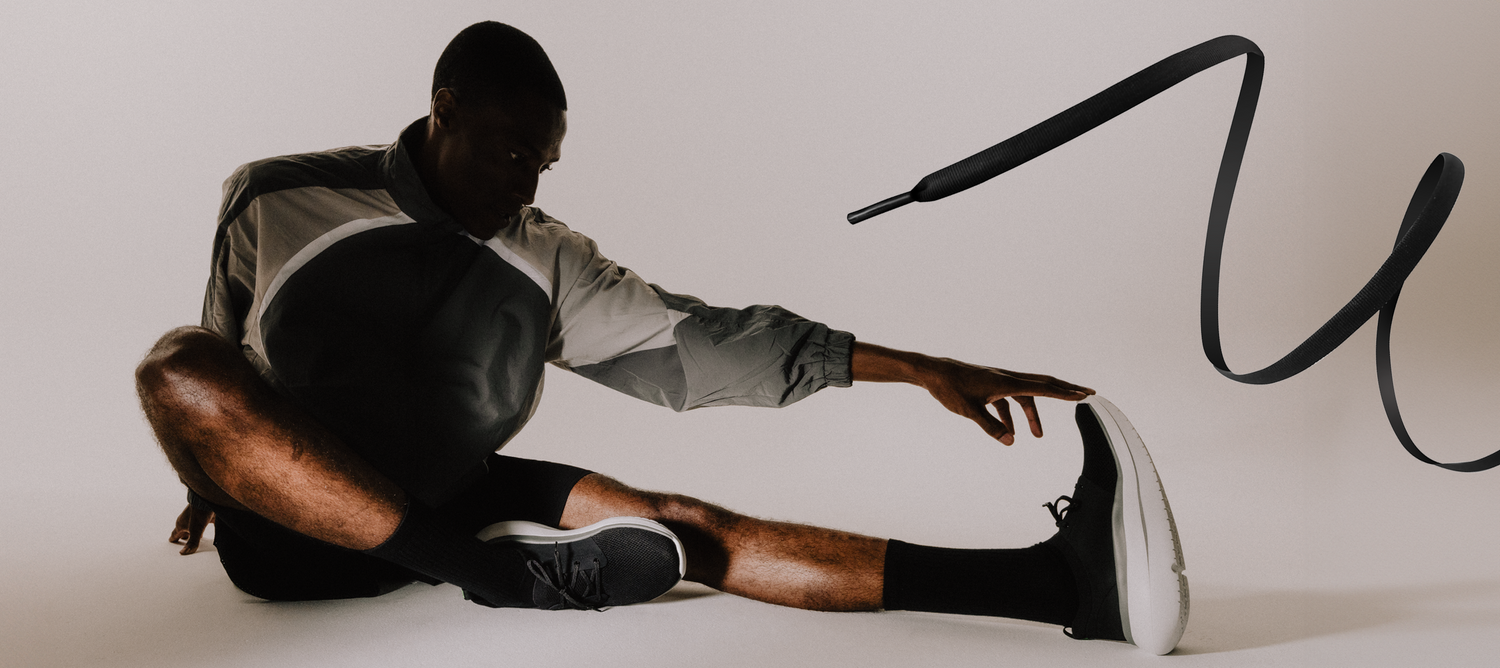 model sitting in studio wearing oomy stride white black