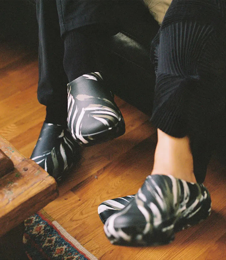 Nok Suntaranon and Greg wearing the TILIT x OOFOS limited-edition Off Hours clogs.