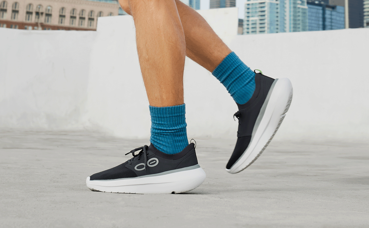 Men's OOmy Stride - White Black side view of model standing outside | lifestyle