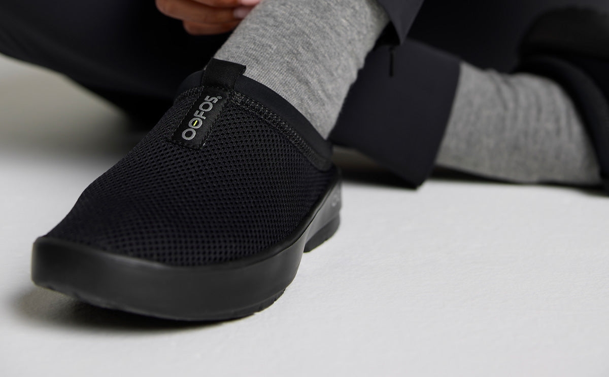 Women's OOcoozie Sport Mule - Black close up of shoe on models foot in studio | lifestyle