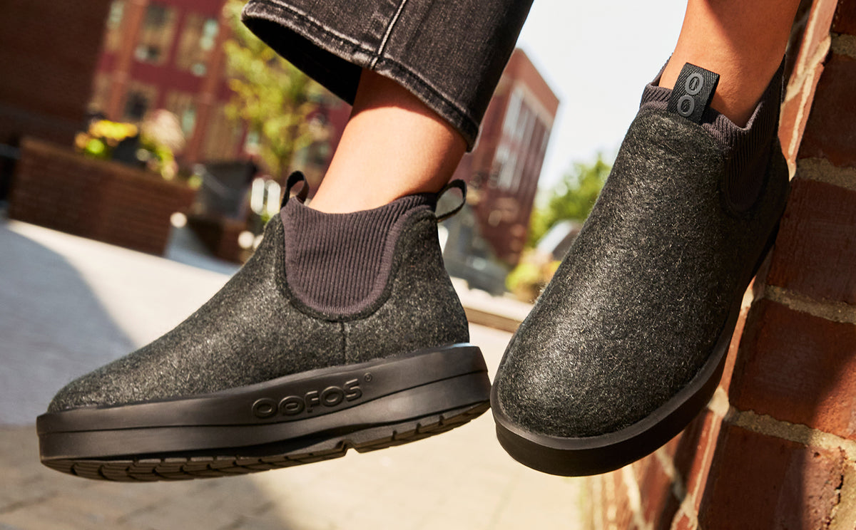 Women's OOmega Londoner - Charcoal model sitting on brick wall outside | lifestyle