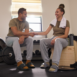 male and female model sitting on studio setting engaging with each other both wearing ooahh sport flex