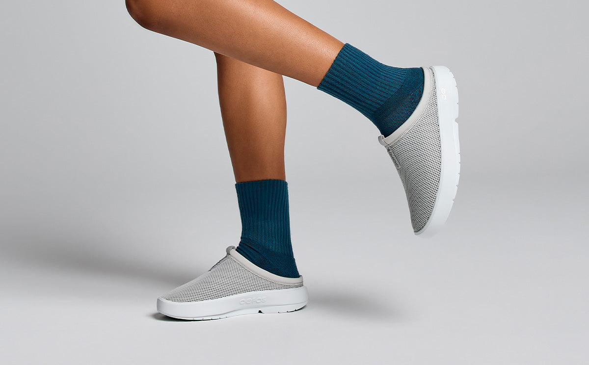 Women's OOcoozie Sport Mule - Gray size view of model in studio with leg up wearing shoes | lifestyle