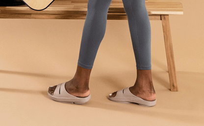 Women's OOahh Slide Sandal - Nomad model standing in studio with tan backgound | lifestyle