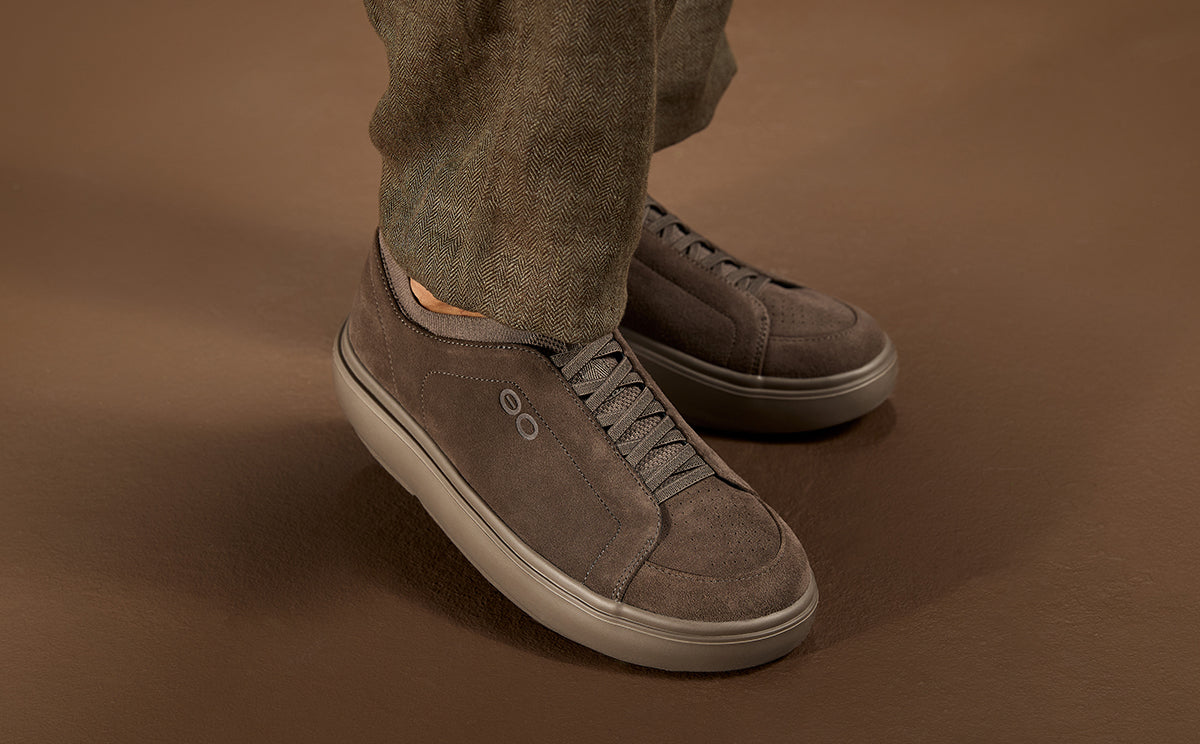 model standing in brown studio wearing suede truffle club plus | lifestyle