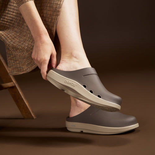 model sitting in studio with brown background wearing portobello clogs