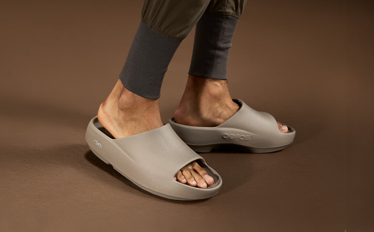 Person wearing driftwood sandals on a brown background | lifestyle