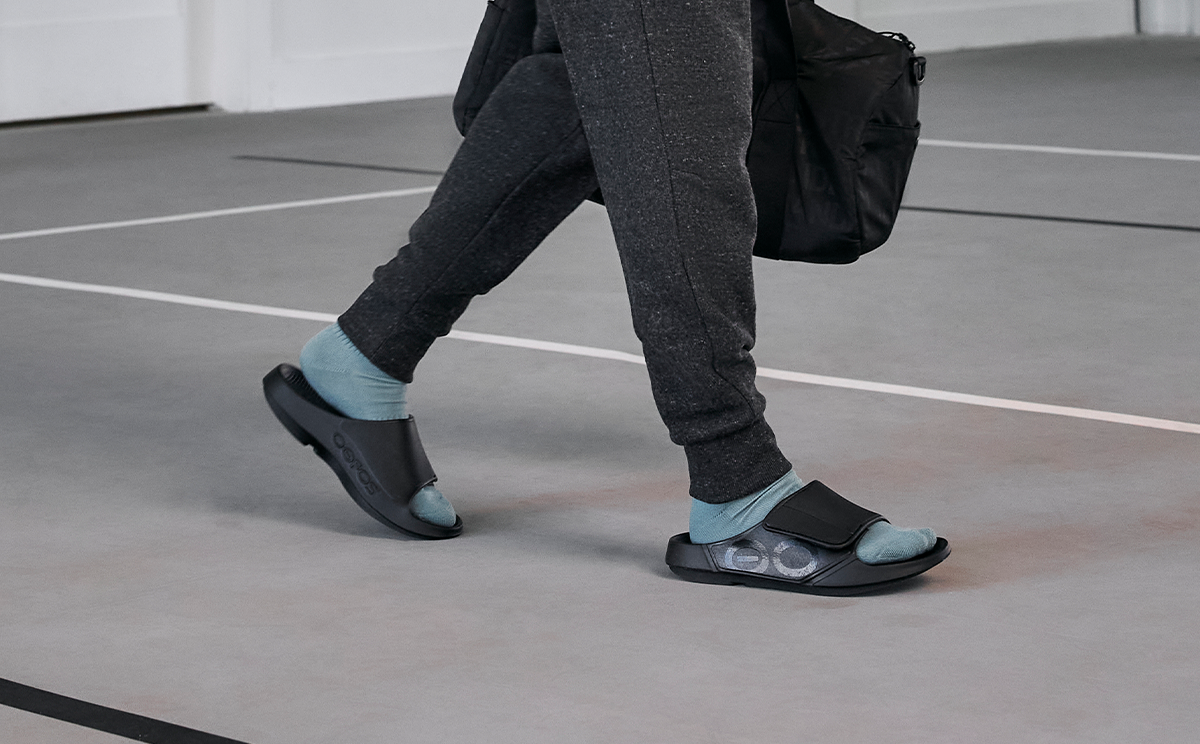 Men's OOahh Sport Flex Sandal - Matte Black modeling walking in gym | lifestyle
