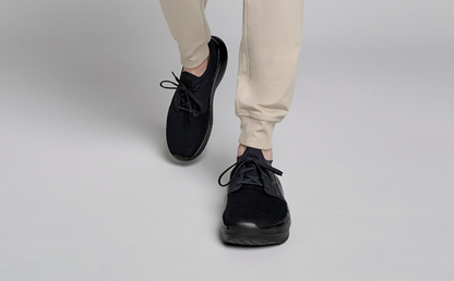 Men's OOmy Stride - Black model walking in studio | lifestyle