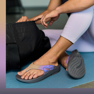 female model sitting on yoga mat wearing ooriginal sport riverstone looking in bag