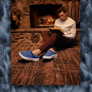 male model sitting on floor by fireplace reading book wearing moroccan blue oocoozie