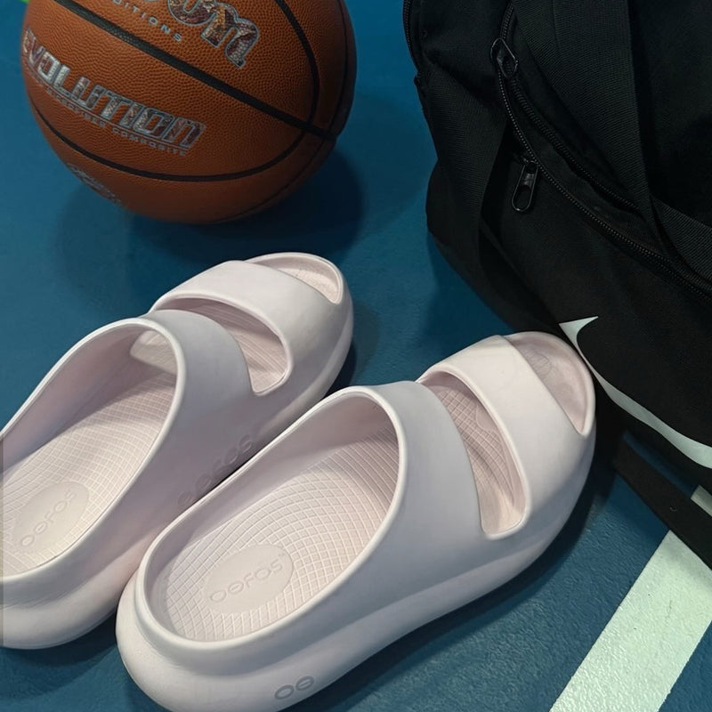 OOFOS slides worn by a student-athlete