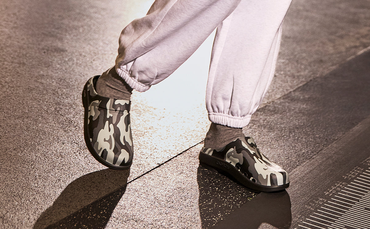 Men's OOcloog Luxe Clog - Night Camo model standing in indoor training facility | lifestyle