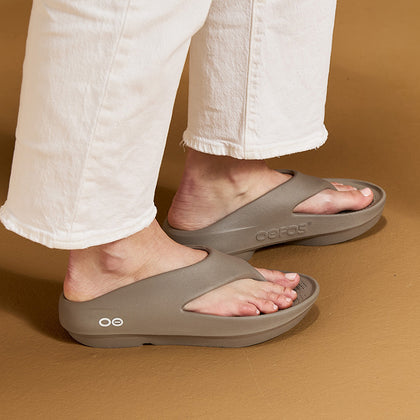 Person wearing driftwood sandals on a brown background | lifestyle