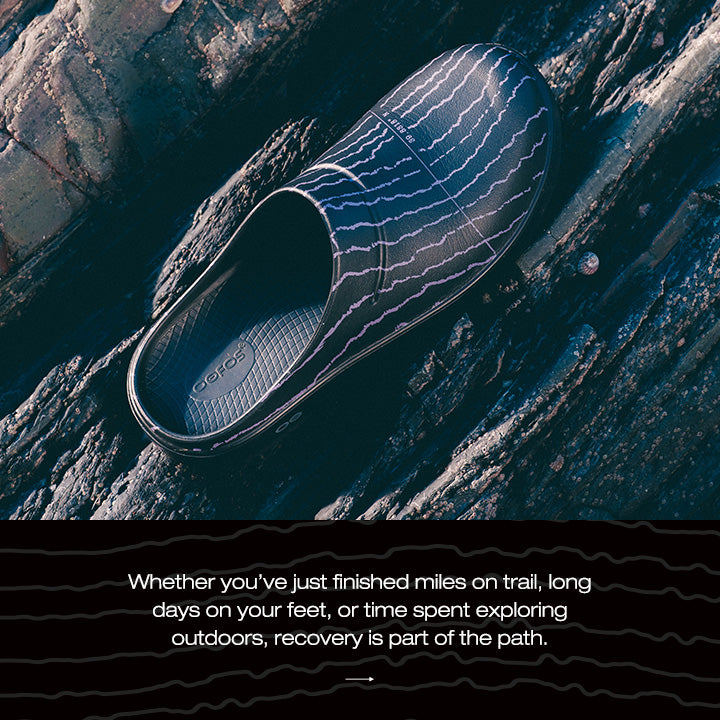 Clog shoe on a rocky surface with a quote about recovery outdoors.
