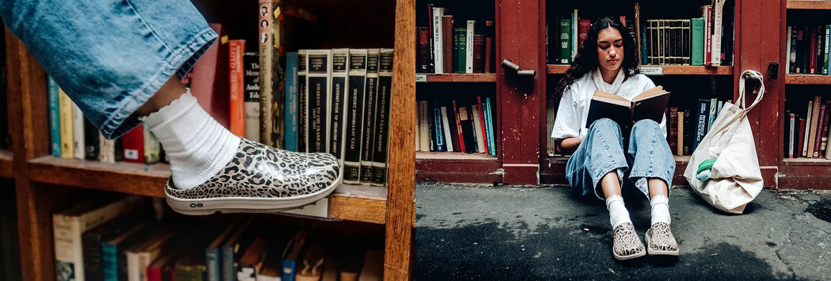 split image of library. one image of model putting foot up on bookshelf wearing nomad leopard cloog. other side model sitting reading